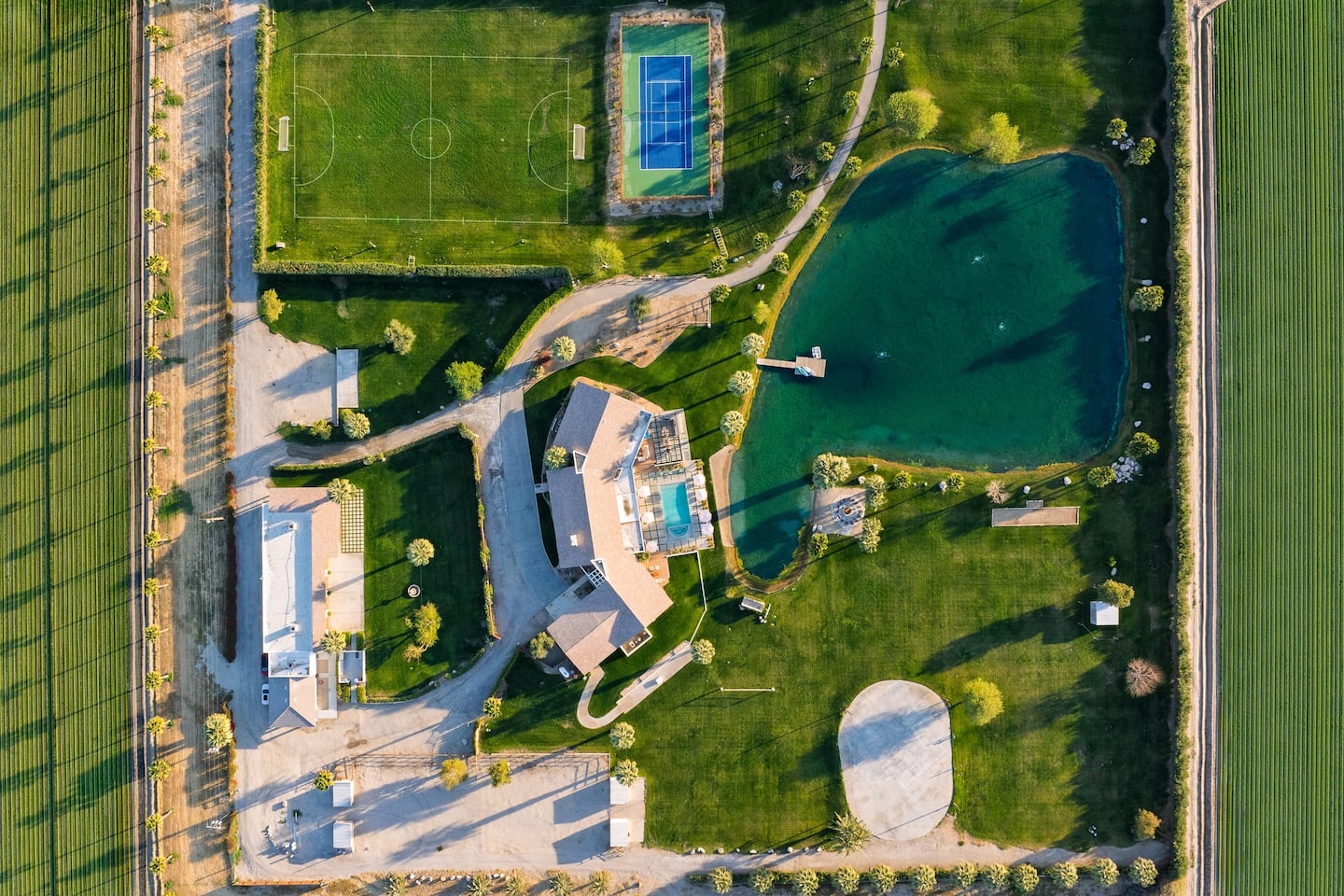 Aerial view of the estate with lake, pool, and sport courts