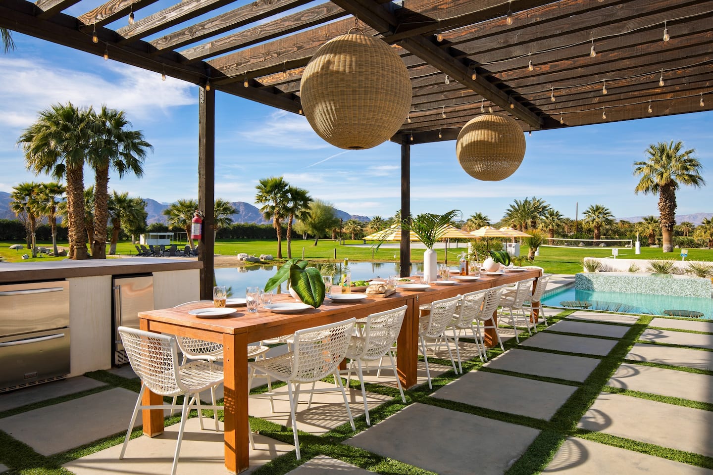 Long communal dining table set for a meal by the pool