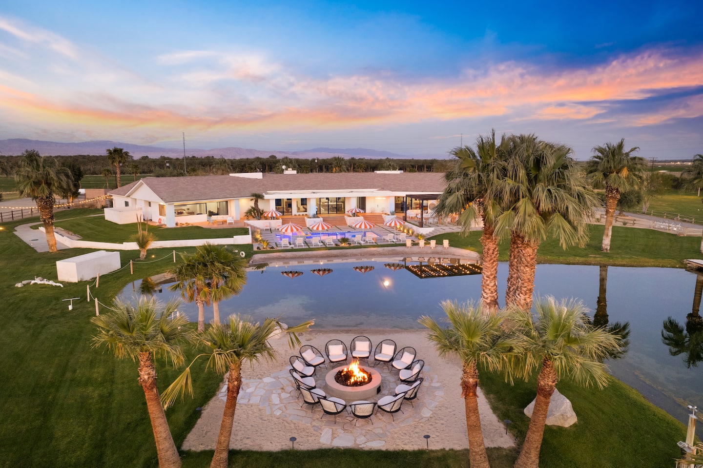 A private 40-acre desert estate with a lake and fire pit at sunset