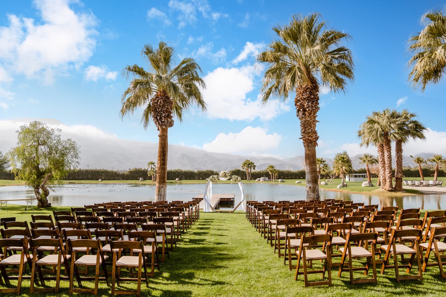 Lakeside gathering space with palms and mountains