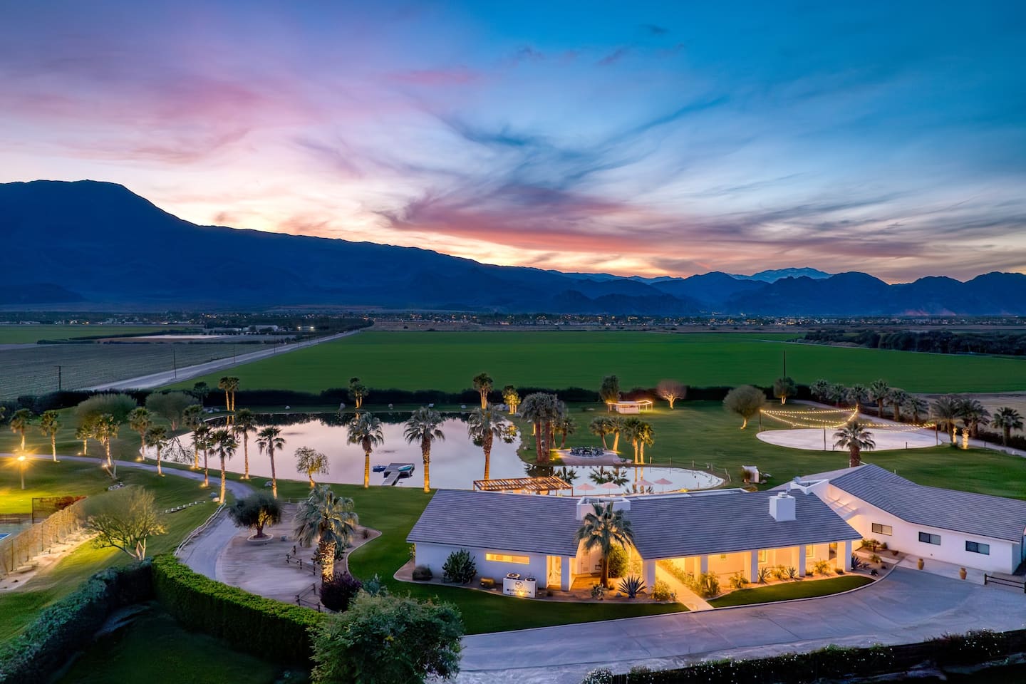 The estate at twilight with desert mountains behind